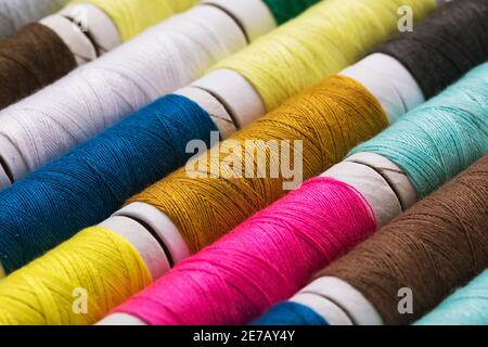 Background from various multi-colored spools of thread, close-up. Stock Photo