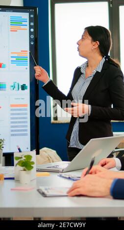 Professional executive manager briefing her collegues, explaning company strategy during brainstorming. Multiethnical businesspeople working in professional startup financial office during conference Stock Photo