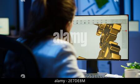 Focused woman architect working at new project using computer doing overtime at night sitting at desk in start-up office. Industrial female engineer studying on pc showing cad software in midnight Stock Photo
