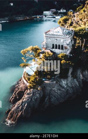 ITALY, PORTOFINO 2021: Aerial view of the panoramic coast of Portofino. In the picture Castello Bonomi (Bonomi Castle) at sunset. Stock Photo