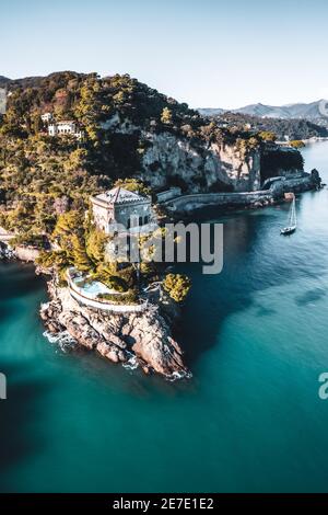 ITALY, PORTOFINO 2021: Aerial view of the panoramic coast of Portofino. In the picture Castello Bonomi (Bonomi Castle) at sunset. Stock Photo