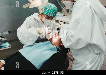 Dental surgeon injecting anesthesia in the mouth. Three people. Dental health concept Stock Photo