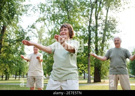 Happy senior people doing morning exercises in the park Stock Photo