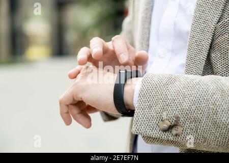 Close-up of young man using his smart watch on his hand while standing in the city Stock Photo