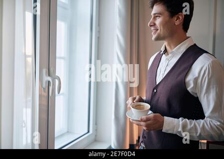 Young businessman preparing for a day while drinking morning coffee Stock Photo