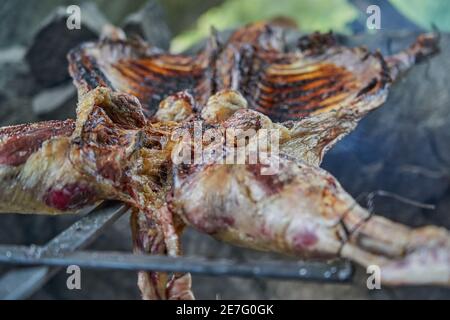 rustic lamb barbecue bbq over open fire in Patagonia, Argentina, South America. Asado is a Gaucho traditon with cooking on open flame Stock Photo