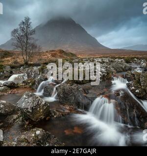 Stunning landscape image of Buachaille Etive Mor waterfall in Scottish highlands on a Winter morning with long exposure for smooth flowing water Stock Photo