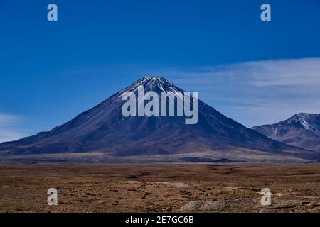 Licancabur is a black stratovolcano on the border between Bolivia and Chile in the high altitude of the altiplano n the andes mountains, South America Stock Photo