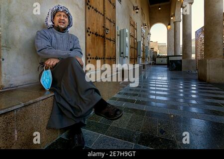 Saudi Arabian men sitting in front of the closed shop in Al Hasa, Saudi Arabia. Stock Photo