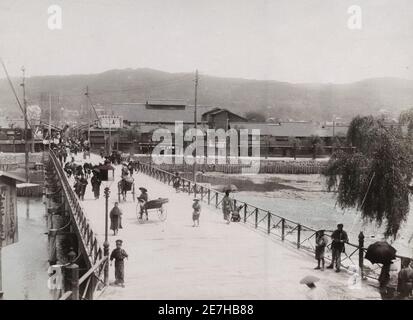 Vintage 19th century photograph: Shijio Bashi, iron bridge, Kyoto, Japan, pedestrians and rickshaws, jinrikishas. Stock Photo