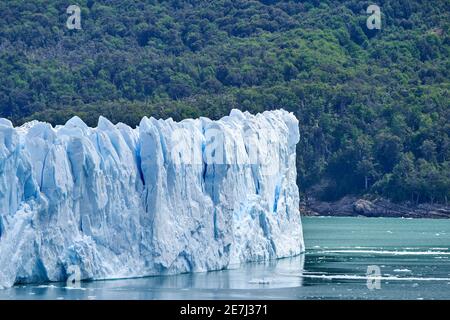 Blue ice of Perito Moreno Glacier in Glaciers national park in Patagonia, Argentina with turquoise water of Lago Argentino in the foreground and dark Stock Photo