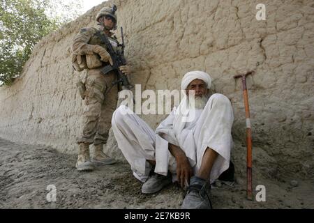 A U.S. Marine from Foxtrot Company, 2nd Battalion, 8th Marines, stands guard next to an Afghan elder at a 'shura', or local council meeting, in Sorkhdoz in Afghanistan's lower Helmand River Valley July 5, 2009. Thousands of Marines advanced into the valley by helicopter and ground this week in the biggest military offensive of Barack Obama's presidency.    REUTERS/Baris Atayman  (AFGHANISTAN CONFLICT MILITARY POLITICS)