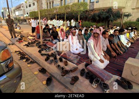 Members of the Committee for the Promotion of Virtue and Prevention of Vice, or religious police, perform dusk prayers with Saudi youth on the street outside coffee shops in Riyadh June 27, 2010. The men conducted the prayers during half-time of the World Cup soccer match between Germany and England, which they had been watching. The police have been ensuring that people watching World Cup soccer matches at the coffee shops continue to conduct their prayers during the duration of the soccer tournament. REUTERS/Fahad Shadeed (SAUDI ARABIA - Tags: SPORT SOCCER WORLD CUP RELIGION IMAGES OF THE DA