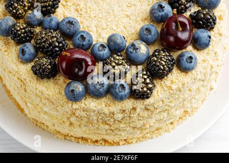 Closeup homemade cake decorated with fresh berries on white wooden table. Shallow focus. Stock Photo