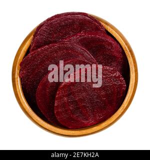 Cooked beetroot slices in a wooden bowl. Boiled sliced red beets also known as table, garden, dinner or golden beets. Beta vulgaris. Taproots. Stock Photo