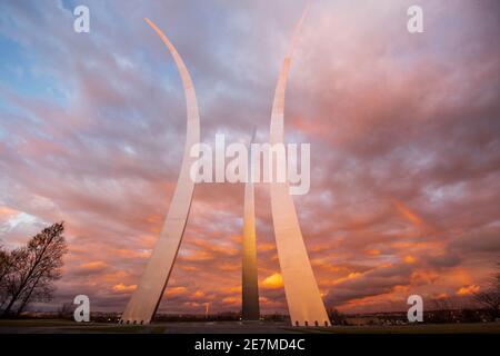 A rainbow can be seen as the sky glows gold and pink during a sunset at the United States Air Force Memorial in Arlington, Virginia. The memorial hono Stock Photo