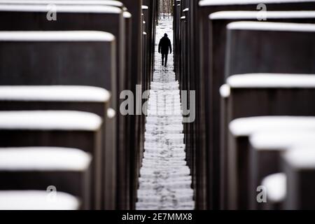 Berlin, Germany. 30th Jan, 2021. Germany, Berlin, January 30, 2021: A man walks on a snowy path at the Memorial to the Murdered Jews of Europe in Central Berlin. Berlin residents are urgently required to reduce physical social contact with people from outside the home to the absolute minimum. People may only leave their home for important reasons. (Photo by Jan Scheunert/Sipa USA) Credit: Sipa USA/Ģ����ý Live News Stock Photo