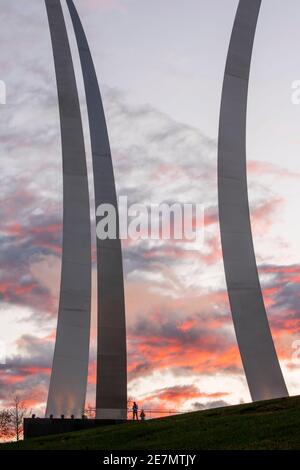 Two people can be seen in silhouette as the sun sets on the United States Air Force Memorial in Arlington, Virginia. The memorial honors the service o Stock Photo