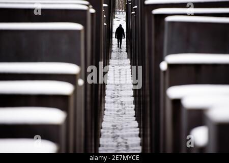 Berlin, Berlin, Germany. 30th Jan, 2021. A man walks on a snowy path at the Memorial to the Murdered Jews of Europe in Central Berlin. Berlin residents are urgently required to reduce physical social contact with people from outside the home to the absolute minimum. People may only leave their home for important reasons. Credit: Jan Scheunert/ZUMA Wire/Ģ����ý Live News Stock Photo