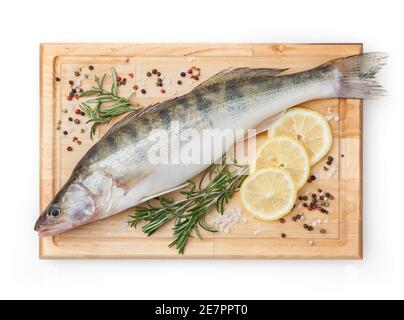Fresh uncooked pike perch with lemon, rosemary and spice on wooden board isolated on white background with clipping path Stock Photo