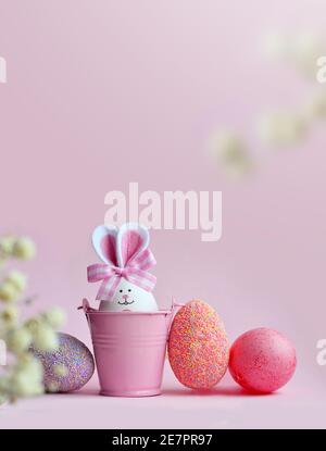 Easter holiday concept with cute handmade eggs, bucket and bunny ears. Easter holiday decoration. Stock Photo