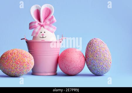 Easter holiday concept with cute handmade eggs, bucket and bunny ears. Easter holiday decoration. Stock Photo