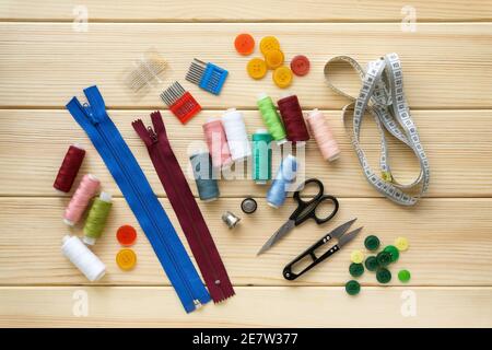 Flat lay of accessories for tailor. Set of sewing supplies on wooden background. Stock Photo