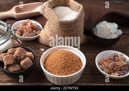 Cane sugar, refined sugar, white and lollipop sugar on a wooden background. Stock Photo