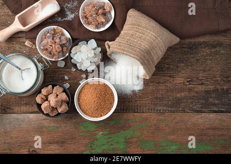 White and cane sugar in different forms on a wooden background. Stock Photo