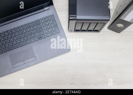 view from above for office workplace with notebook and nas backup server on a wooden background. Stock Photo