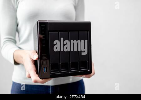 female holds small nas backup server. data backup and security concept. Stock Photo