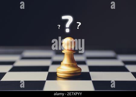 Confusion concept with question marks above a chess piece. Stock Photo