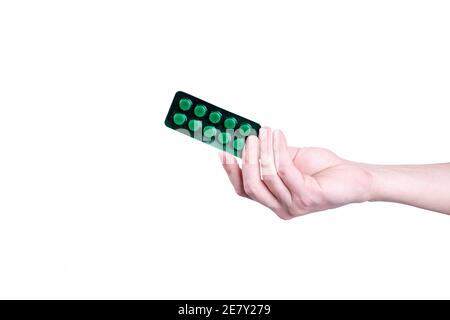 green medical drug pills blister in hand isolated on white background. Stock Photo