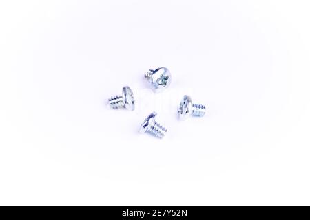 four silver colored screws on white background. screws used for computer hardware Stock Photo