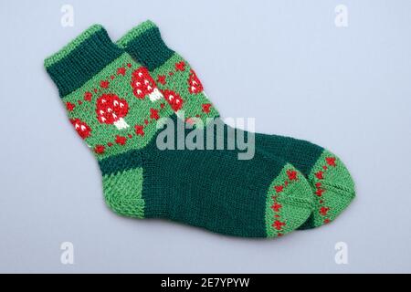 a woolen socks with amanita print on neutral background Stock Photo