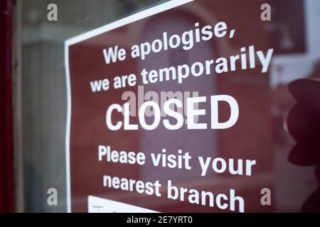 Red sign on the door of a small shop, stating that it is closed during the national lockdown during the covid pandemic in the united kingdom Stock Photo