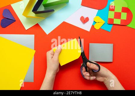 DIY instruction. Step by step guide. The process of making a paper heart from yellow and gray colored paper for Valentine's Day. Stock Photo