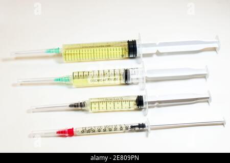 Isolated shot of some medical syringes of different sizes on the sterile table with liquid vaccine Stock Photo