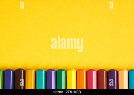 colored pencil on bright yellow background. view from above. bottom border. pencils with grey body and colored tips. vibrant colors Stock Photo
