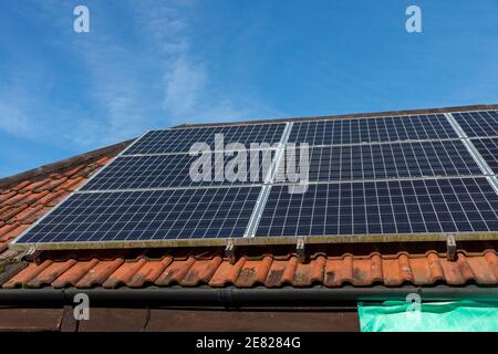 a close up view of solar panels on a old tiled roof Stock Photo