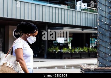 African lady taking a walk wearing a white mask. Stock Photo