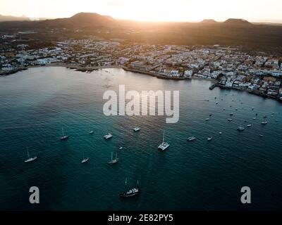 Sailing boats in Corralejo bay aerial drone shot. Sunset behind the mountains. Fuerteventura, Canary Islands Stock Photo