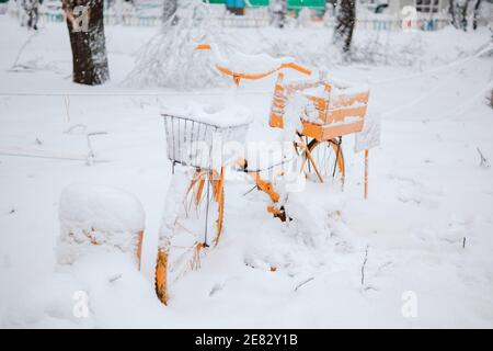 Decorative Vintage Model Old bike orange Equipped Basket Snowy At Winter Day. Stock Photo