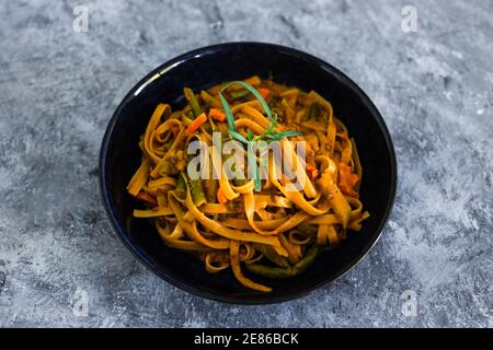 healthy plant-based food recipes concept, vegan fettuccini with mixed vegetables and creamy sauce Stock Photo