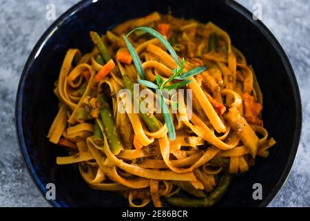 healthy plant-based food recipes concept, vegan fettuccini with mixed vegetables and creamy sauce Stock Photo