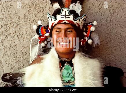 A young Native American man poses in ceremonial dress during a celebration  of Indian culture by indigenous peoples of America who gathered to dance,  sing and honor the traditions of their ancestors.
