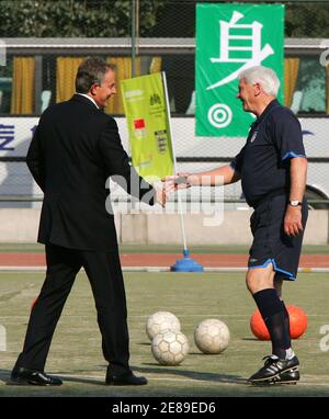 British Prime Minister Tony Blair greets former England soccer manager Sir Bobby Robson (R) at a football session with young Chinese soccer players at a stadium in Beijing September 6, 2005. Blair, relaxing after two days of political talks, joined Robson and some 40 budding Chinese footballers at the stadium in the Chinese capital to kick off a programme of Sino-British cooperation in sports, media and arts. REUTERS/Claro Cortes IV  CC/YH