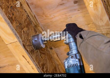 Pumping contractor for drilling hole in joist for ABS and PVC drain pipe on sewage pipeline Stock Photo