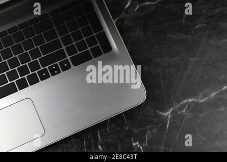 Laptop on black rough marble surface. Selective focus Stock Photo
