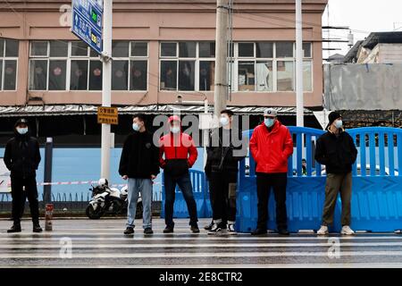 Security personnel stand guard outside Huanan seafood market during the visit by the World Health Organization (WHO) team tasked with investigating the origins of the coronavirus disease (COVID-19), in Wuhan, Hubei province, China January 31, 2021. REUTERS/Thomas Peter